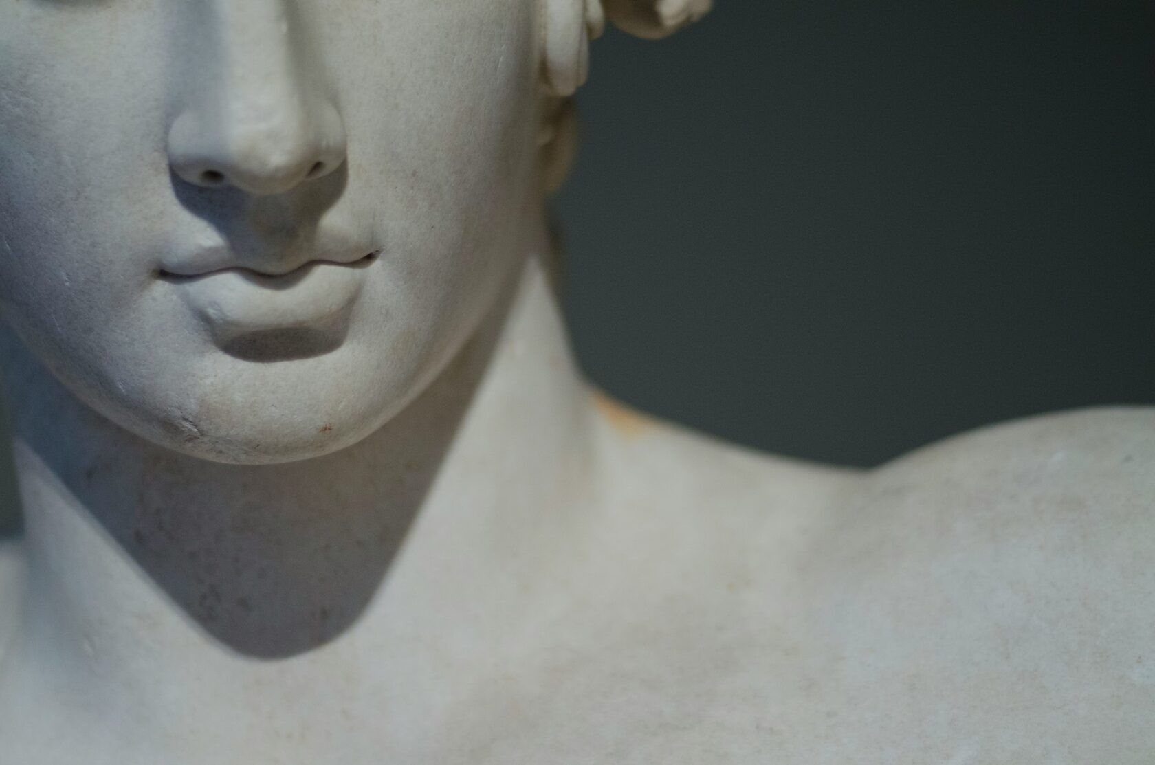 Detalhe de superfície de escultura em mármore branco, mostrando o polimento manual e a luz reflectida na pedra